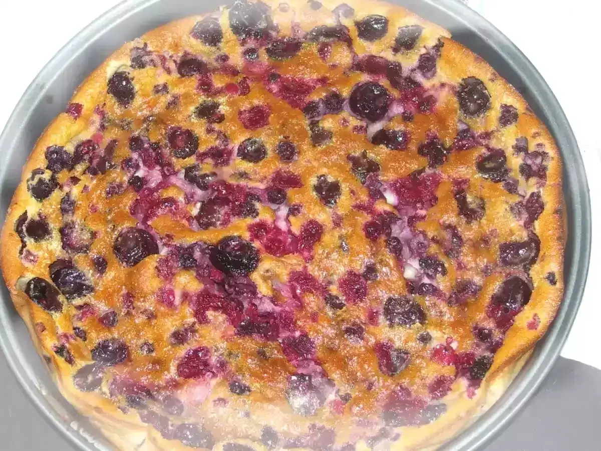 Un délicieux clafouti aux fruits rouges, tout juste sorti du four, avec ses myrtilles et framboises fondantes.