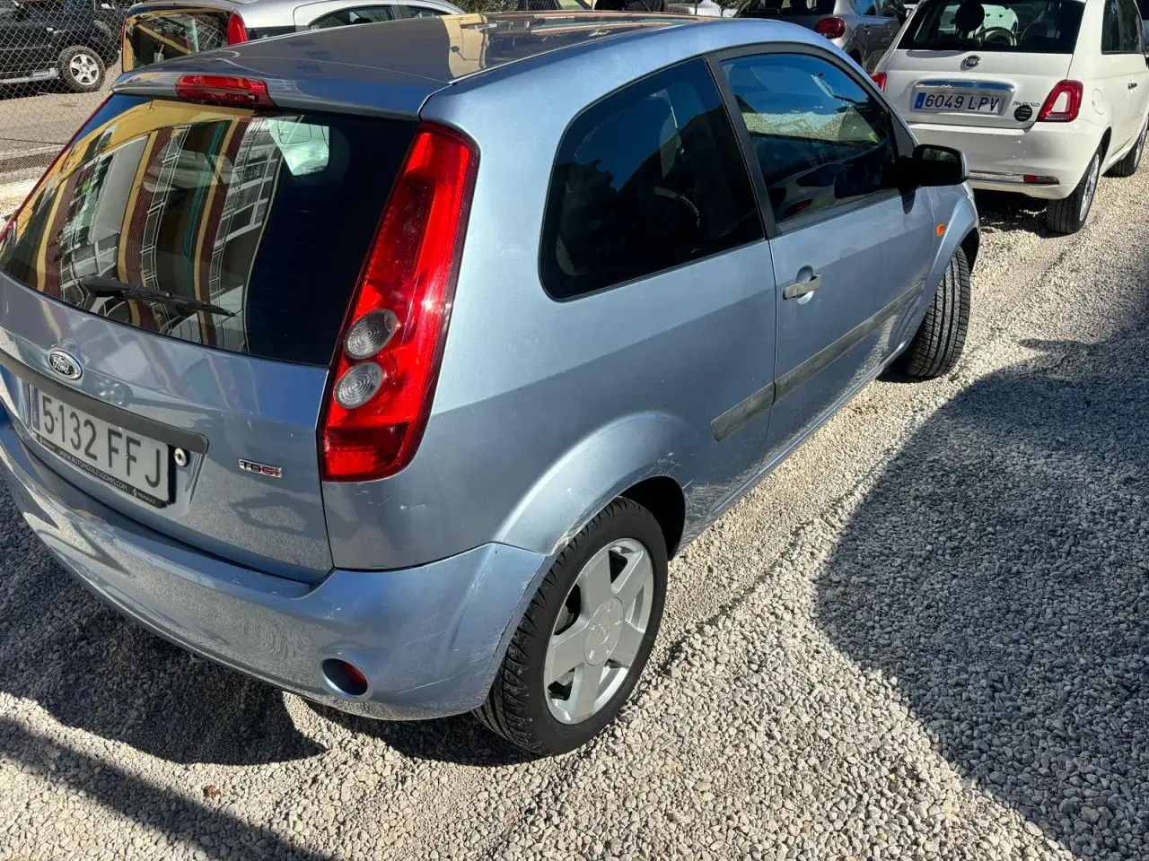 Ford Fiesta 1.4 TDCI con algunos problemas visibles, aparcado sobre grava.