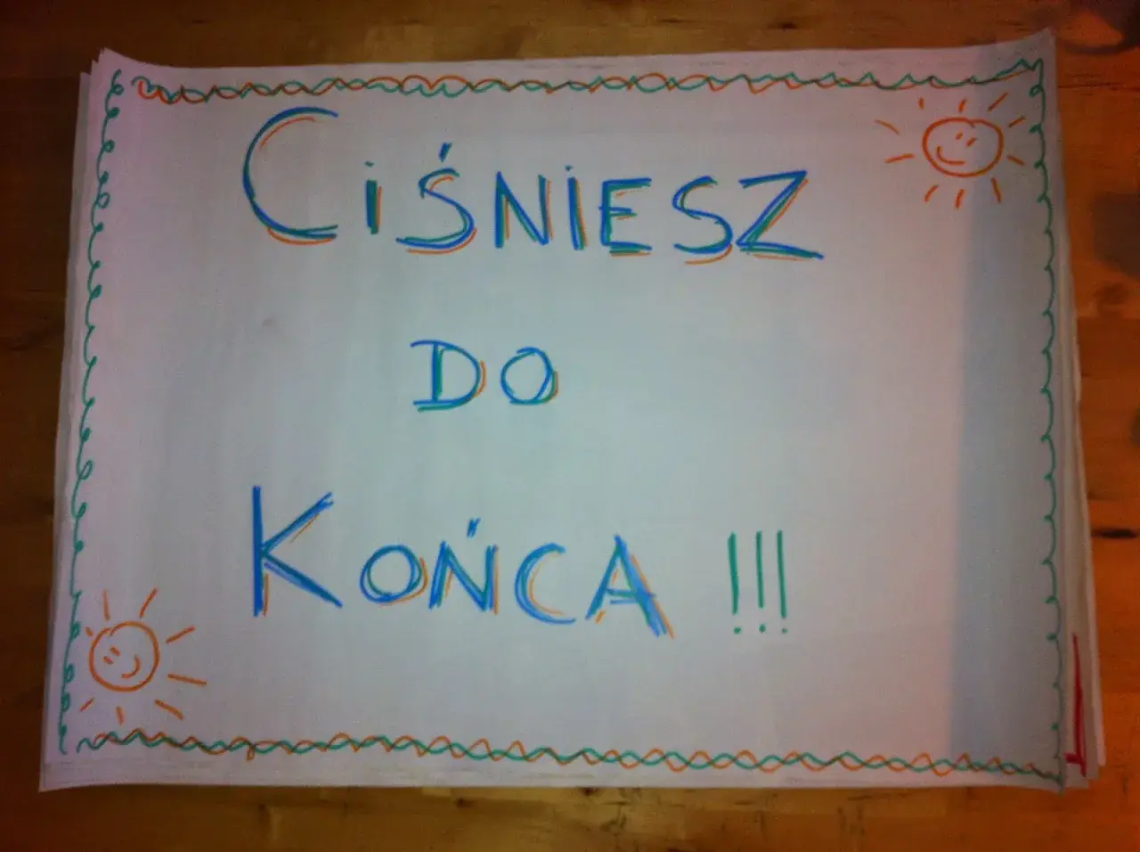 Hasła dopingujące biegaczy: "Ciśniesz do końca !!!" z uśmiechniętymi słoneczkami po bokach.