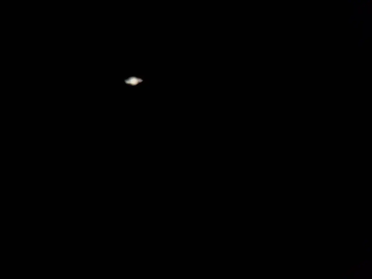 Saturn przez lornetkę. Widoczny pierścień gazowego olbrzyma, jakby namalowany pędzlem.
