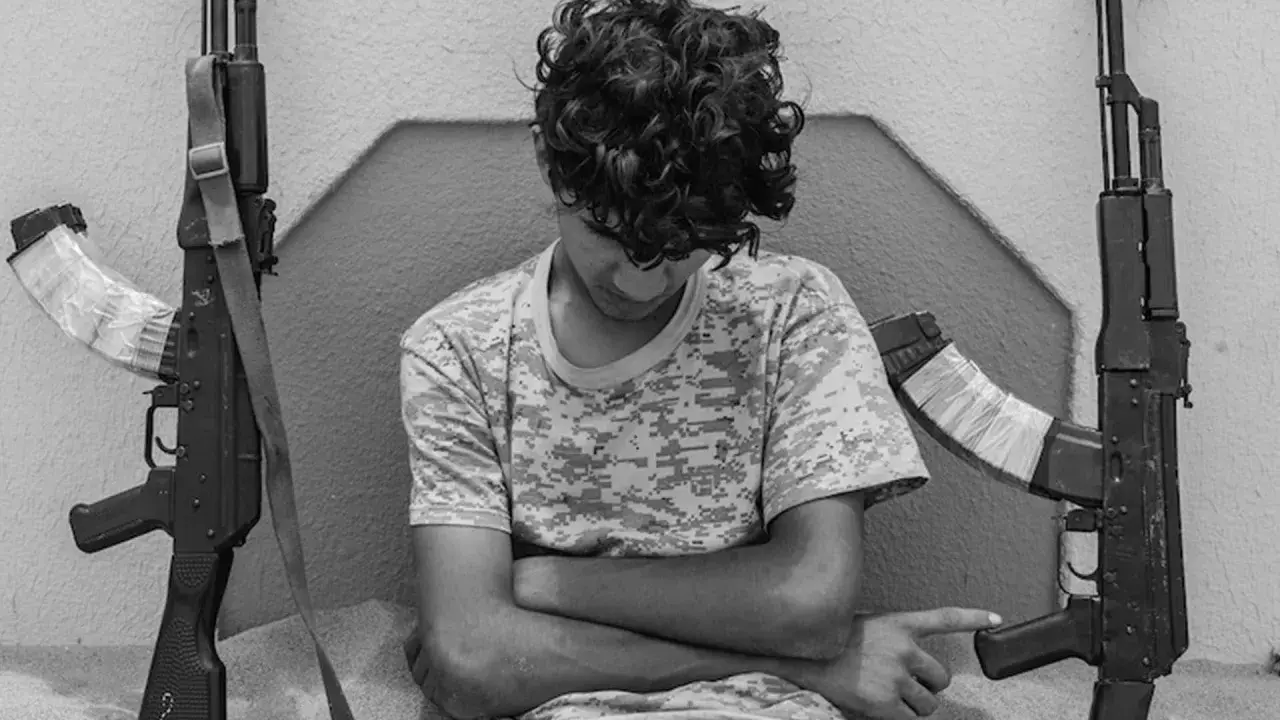 Ragazzo con fucili, uno scatto intenso di Micalizzi fotografo.