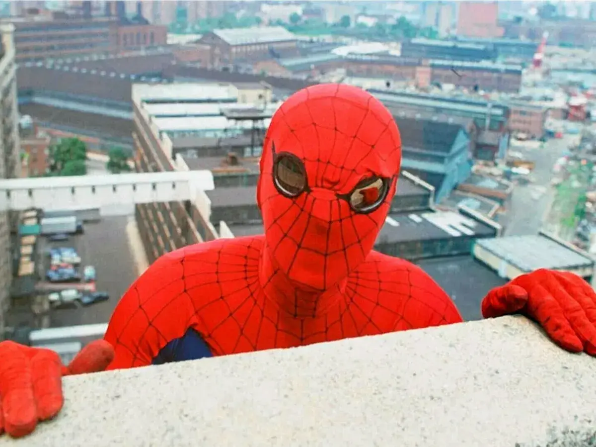 Le premier Spiderman acteur, Nicholas Hammond, se penche au-dessus d'un mur, regardant la ville.