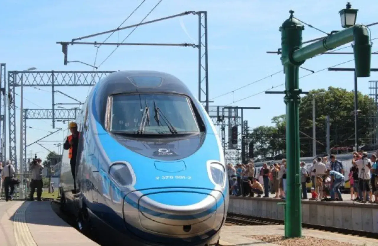 Błękitno-srebrny pociąg EIP, czy to Pendolino? Stoi na peronie, a wokół zgromadził się tłum ciekawskich.