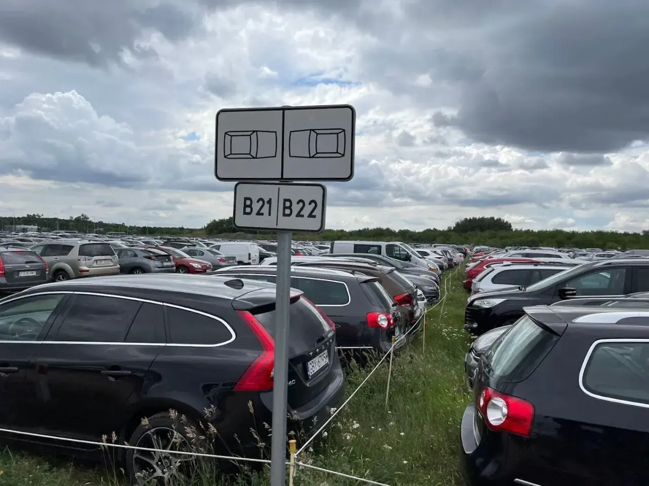 Duży parking z rzędami samochodów, znak B21 B22. Idealne miejsce na **valet parking**, gdzie Twój samochód jest bezpieczny.