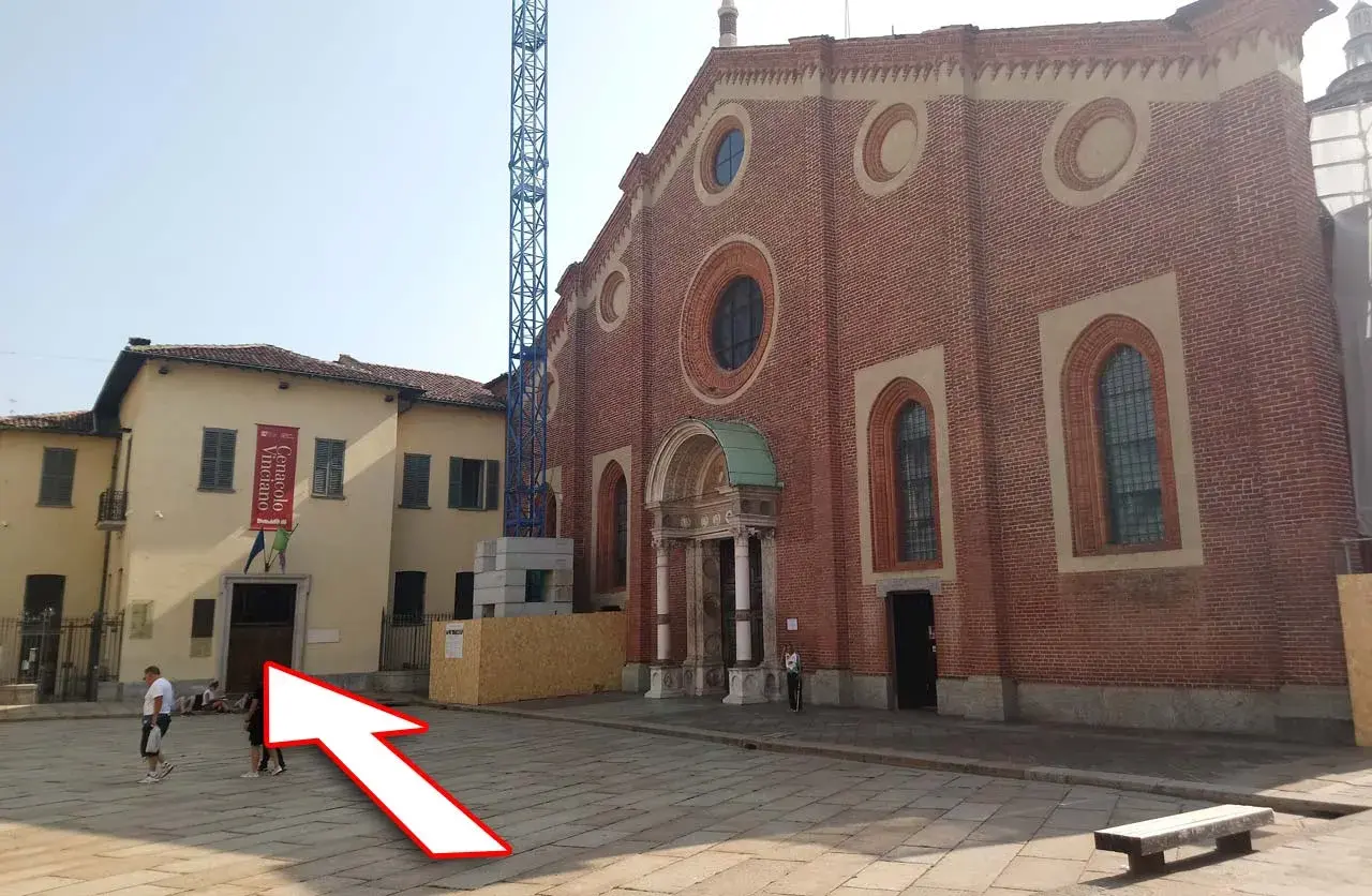 Plac przed kościołem, gdzie można kupić bilety na Ostatnią Wieczerzę. W tle budynek z banerem "Cenacolo Vinciano".
