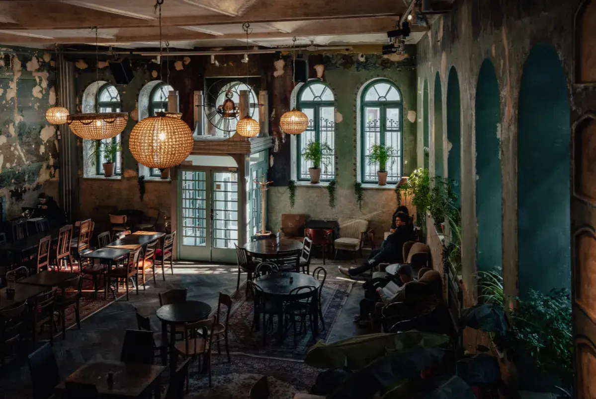 Wnętrze pełne uroku, z dużymi, okrągłymi lampami i zielonymi akcentami. Idealne miejsce na relaks w jednej z klimatycznych restauracji w Krakowie.
