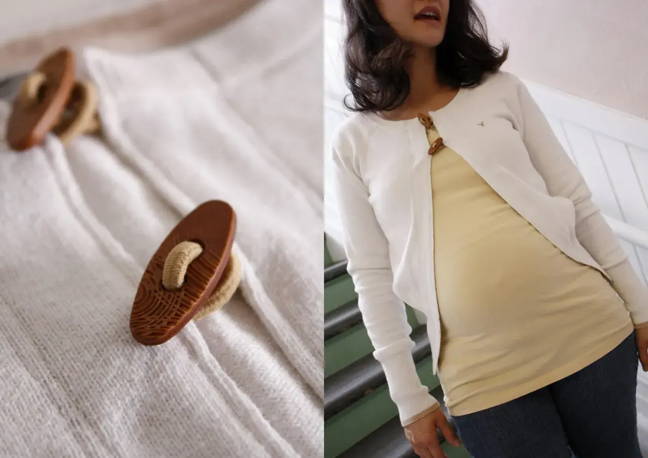 Zbliżenie na drewniane guziki swetra i kobieta w białym swetrze nałożonym na żółtą bluzkę.