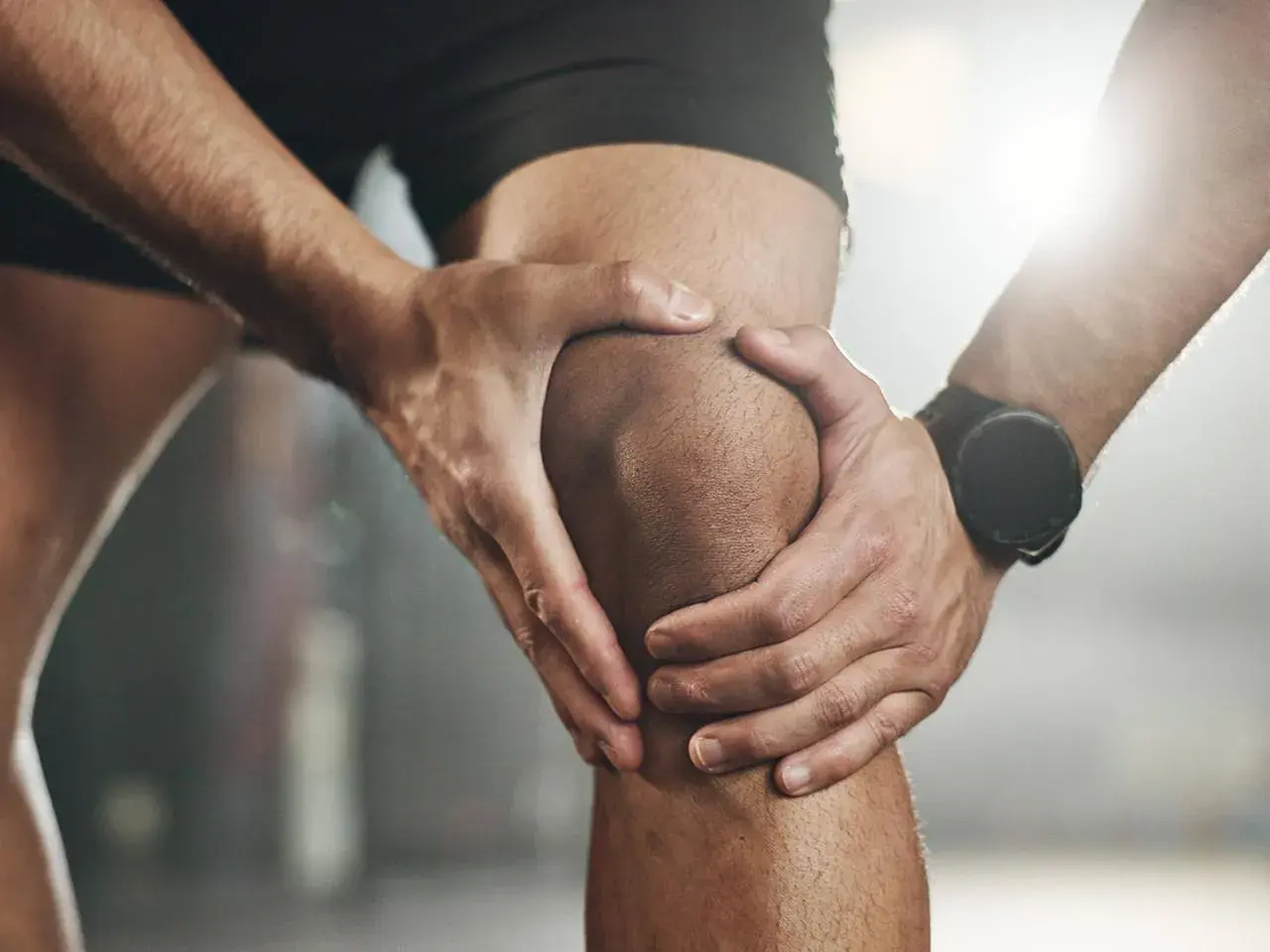 Sportler hält schmerzendes Knie. Möglicher Kreuzbandriss? Ein Selbsttest kann erste Hinweise geben.