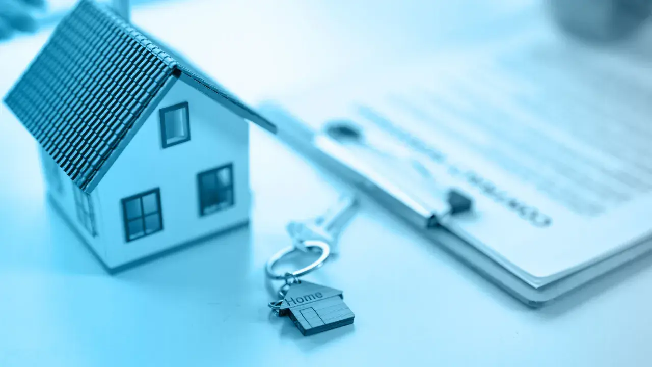 Modellino di casa, chiavi con ciondolo a forma di casa e documenti pronti per vendere casa.