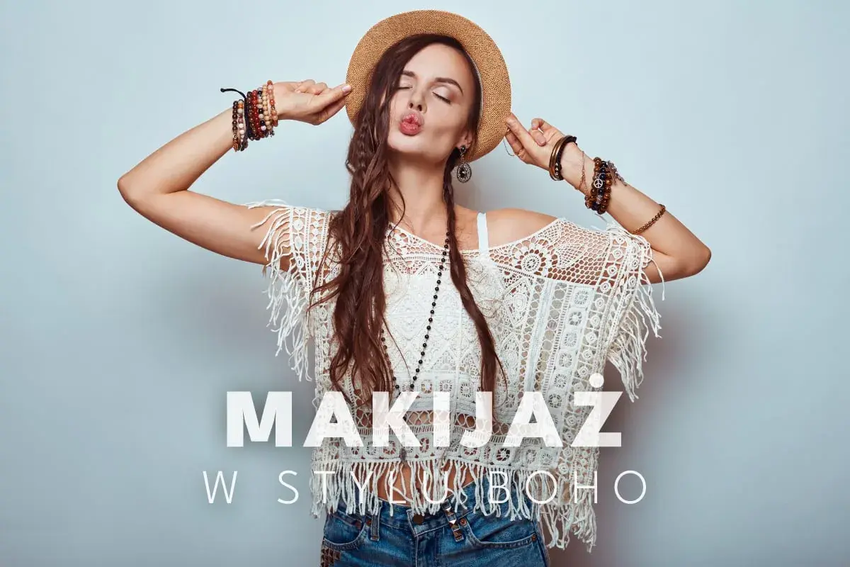 Kobieta w kapeluszu i koronkowej bluzce z frędzlami, z mnóstwem bransoletek. Jej makijaż boho podkreśla swobodny styl.