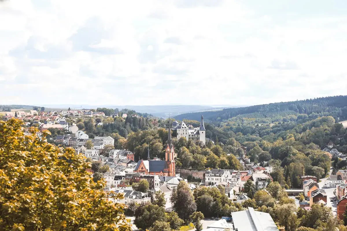 Idyllisches Städtchen mit Schloss und Kirche, umgeben von grünen Hügeln. Perfekt für Ausflugsziele Sachsen.