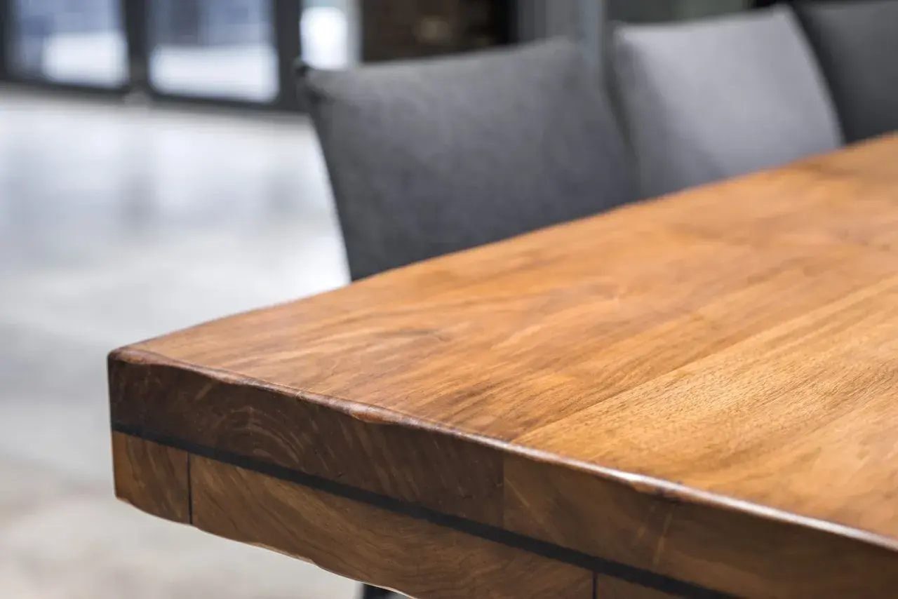 A close-up of a beautiful acacia wood table, showcasing its rich grain and warm tones. Is acacia wood good? This table suggests yes!