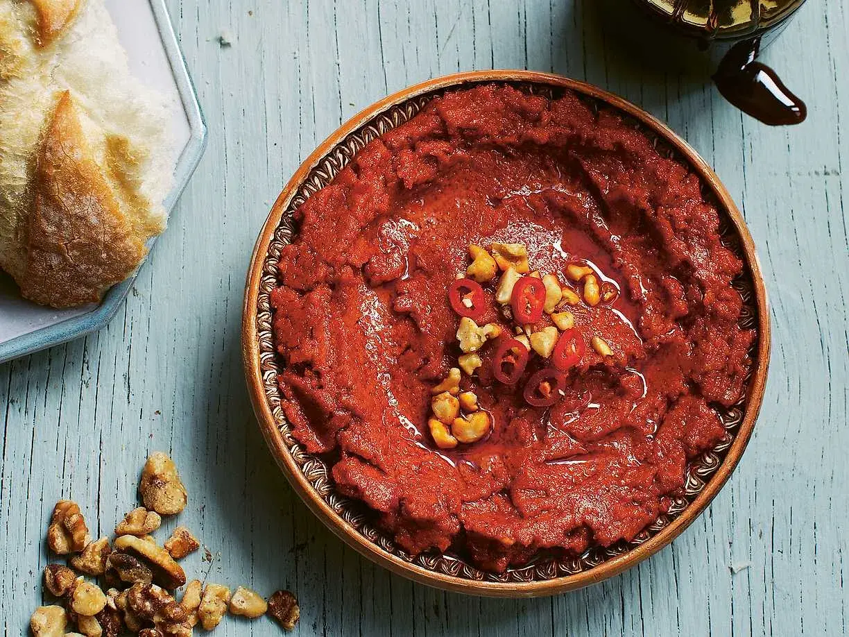 En skål med mustig muhammara, toppad med nötter och chili. Perfekt till nybakat bröd.