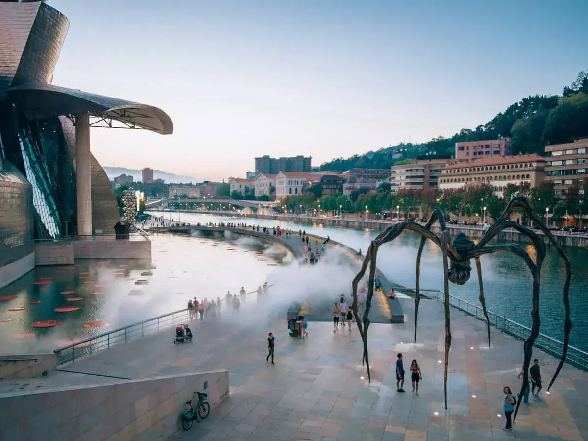 Gigantyczny pająk strzeże Muzeum Guggenheima w Bilbao. Wspaniałe bilbao atrakcje zachwycają o zmierzchu.