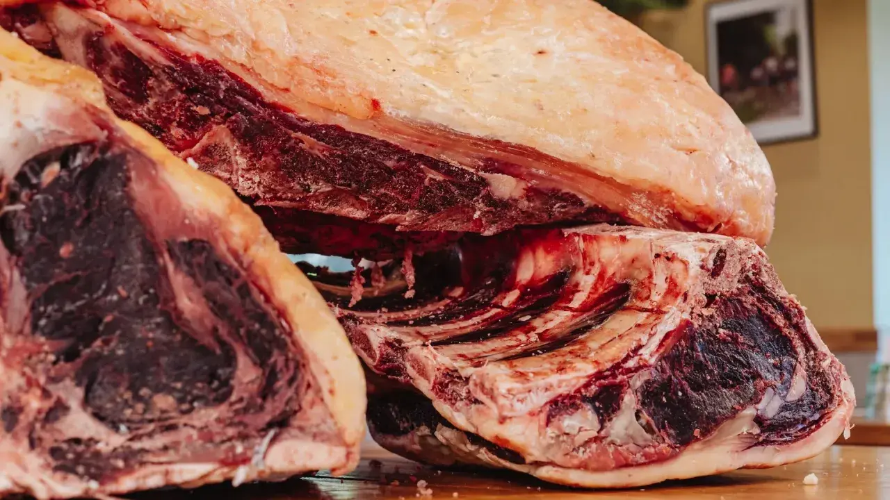 Gros morceaux de bœuf, prêts pour le dry aging, révélant une viande rouge foncée et une belle couche de gras.