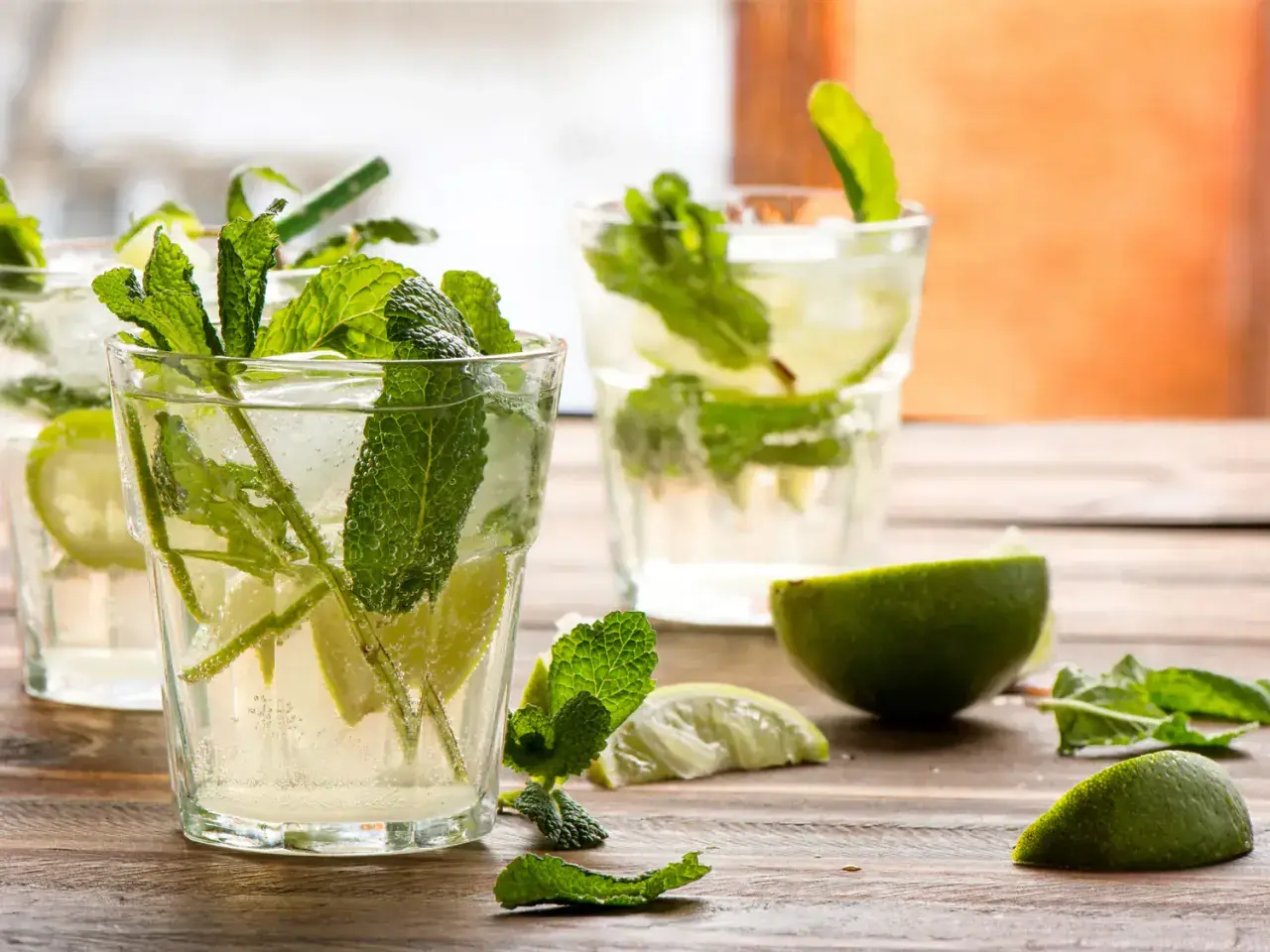 Verre de mojito frais avec menthe, citron vert et glaçons. Parfait pour une recette mojito rafraîchissante.