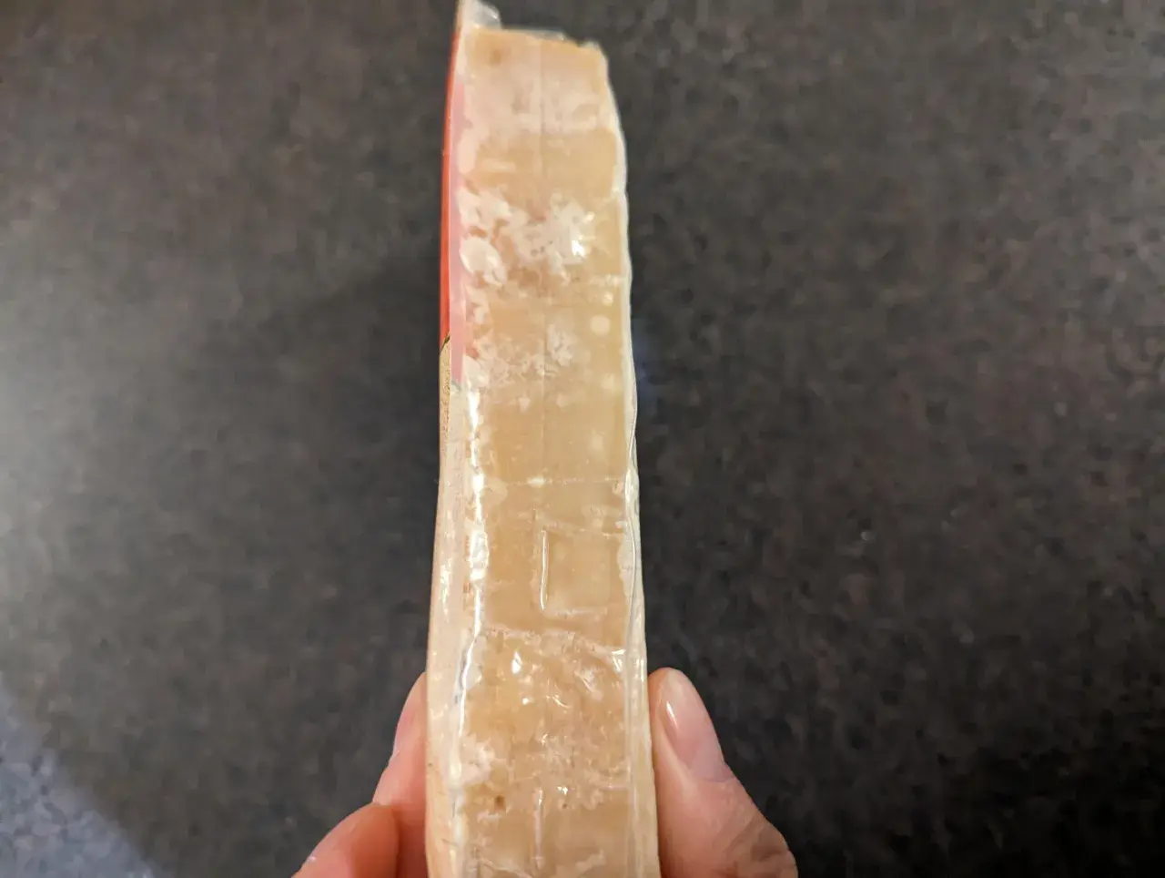 Un pezzo di formaggio stagionato, forse formaggio scaduto si può mangiare se non presenta muffe strane.