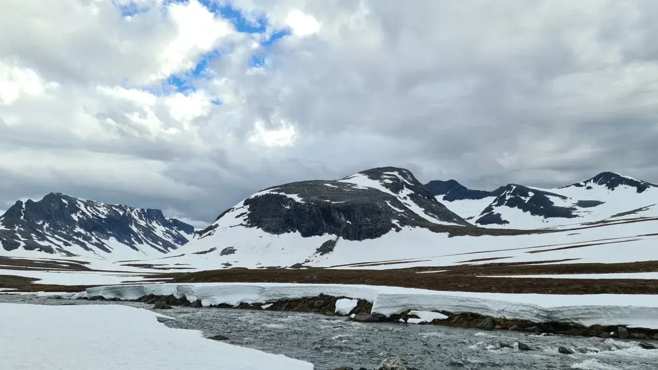 Snöklädda berg och en forsande älv i Jämtland. En dröm att bestiga Sylarna i detta landskap.