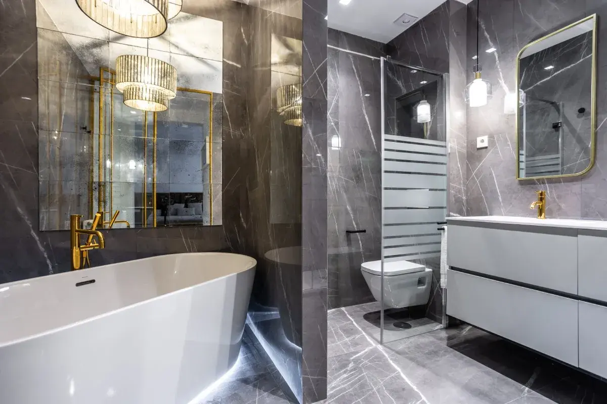 Elegante baño con bañera, ducha, inodoro y lavabo. La lámpara espejo baño ilumina el espacio con un toque de lujo.