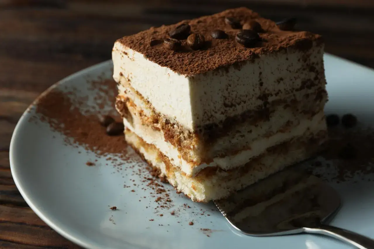 Pyszne tiramisu włoskie, warstwowe ciasto z kremem i kakao, ozdobione ziarnami kawy.