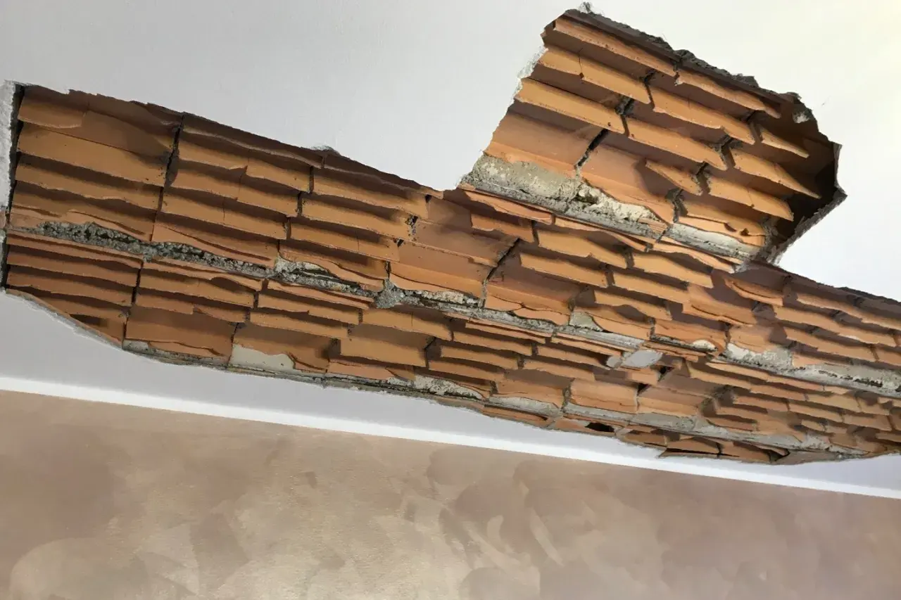 Sfondellamento pignatte: il soffitto mostra mattoni a vista e crepe, necessita di una soluzione rapida.