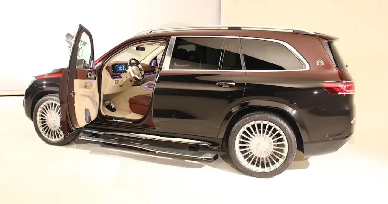 Mercedes-Maybach GLS z otwartymi drzwiami, widoczne luksusowe wnętrze i dwukolorowe nadwozie.
