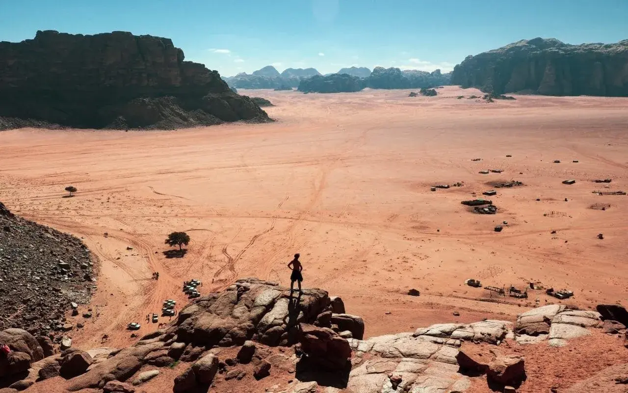 Pustynia Wadi Rum w Jordanii, gdzie turysta podziwia krajobraz. Wiza do Jordanii otwiera drogę do takich widoków.