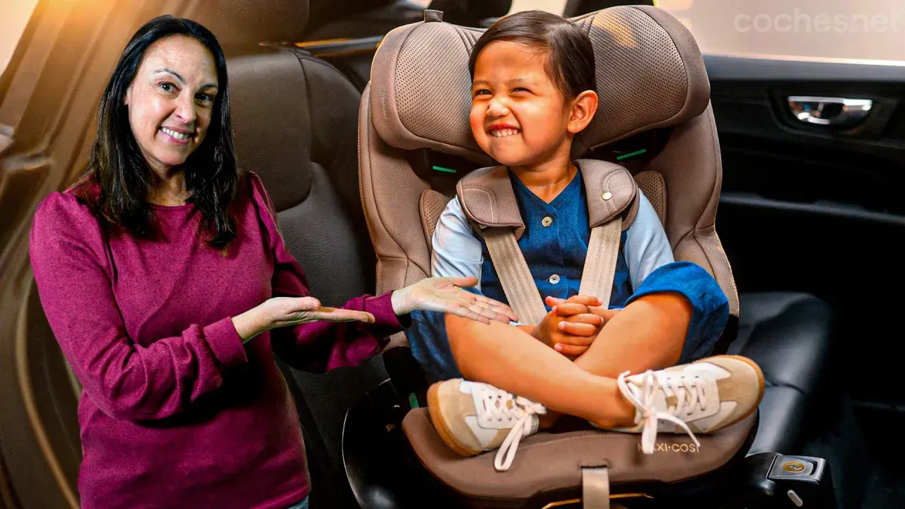 Una mujer sonríe mientras señala a un niño feliz sentado en su silla de coche. ¡Los niños en el coche están seguros y contentos!