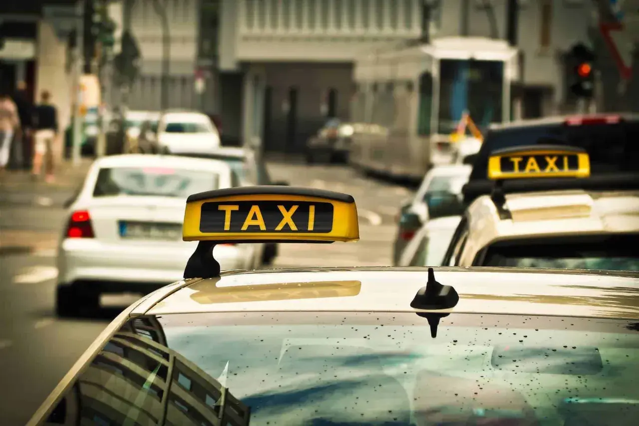 Gelbes Taxi-Schild auf einem Auto in einer Stadt. Ein Taxi in Polen wartet auf Fahrgäste.