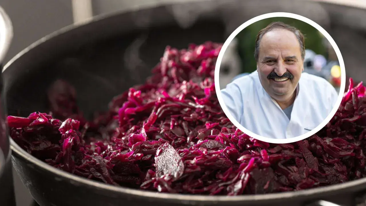 Ein Koch lächelt, während er dampfendes Blaukraut verfeinert.