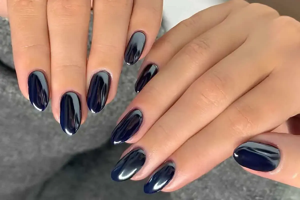 Manucure noir aux reflets métalliques, des ongles élégants et modernes.