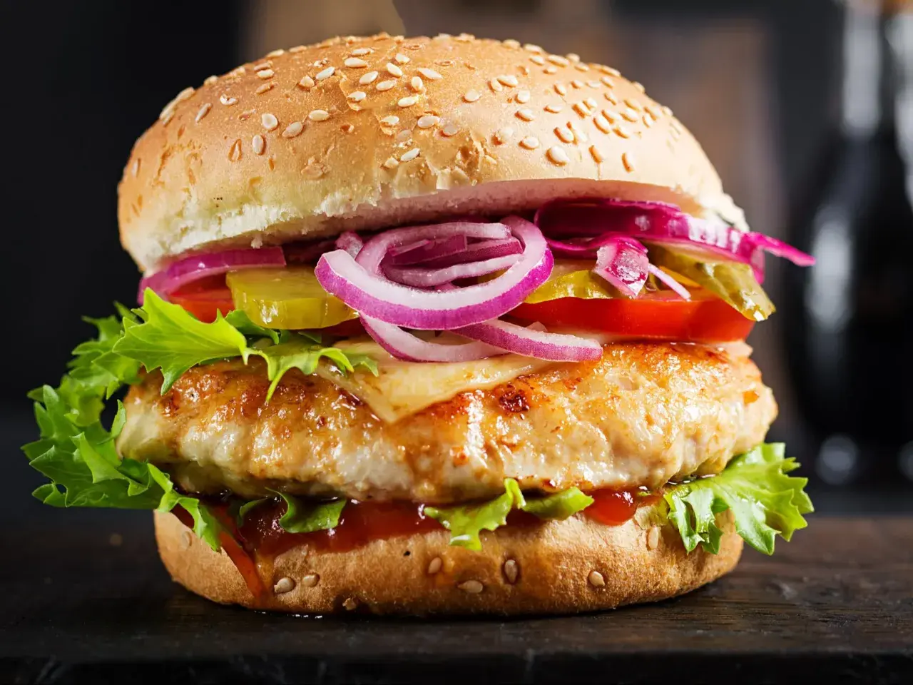 Apetyczny burger drwala podwójny z soczystym kurczakiem, serem, chrupiącą sałatą, pomidorem, ogórkiem i czerwoną cebulą.