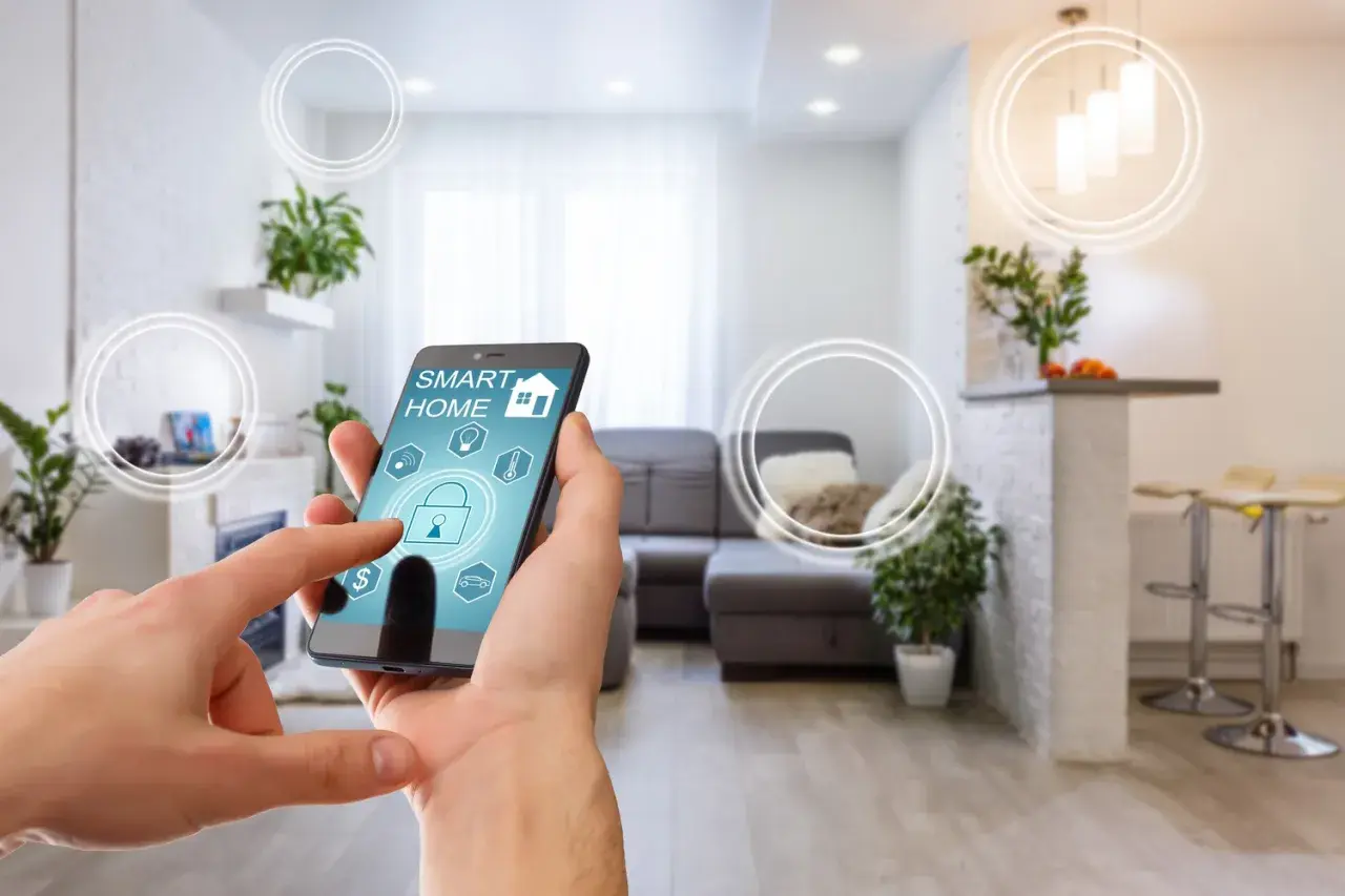 Mano interactuando con app "SMART HOME" en un smartphone, controlando una casa tecnológica moderna con luces y seguridad.
