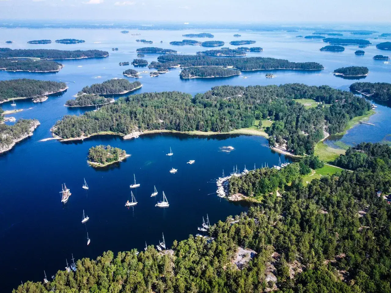 Archipelag szwedzki, gdzie liczne wyspy tworzą malowniczy krajobraz. Ile wysp ma Szwecja? Tysiące! Widać tu żaglówki i zielone wysepki.