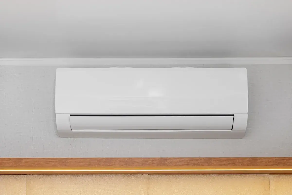 Unità interna di condizionatore bianco montata a parete, con canalina nascosta per un'installazione pulita.
