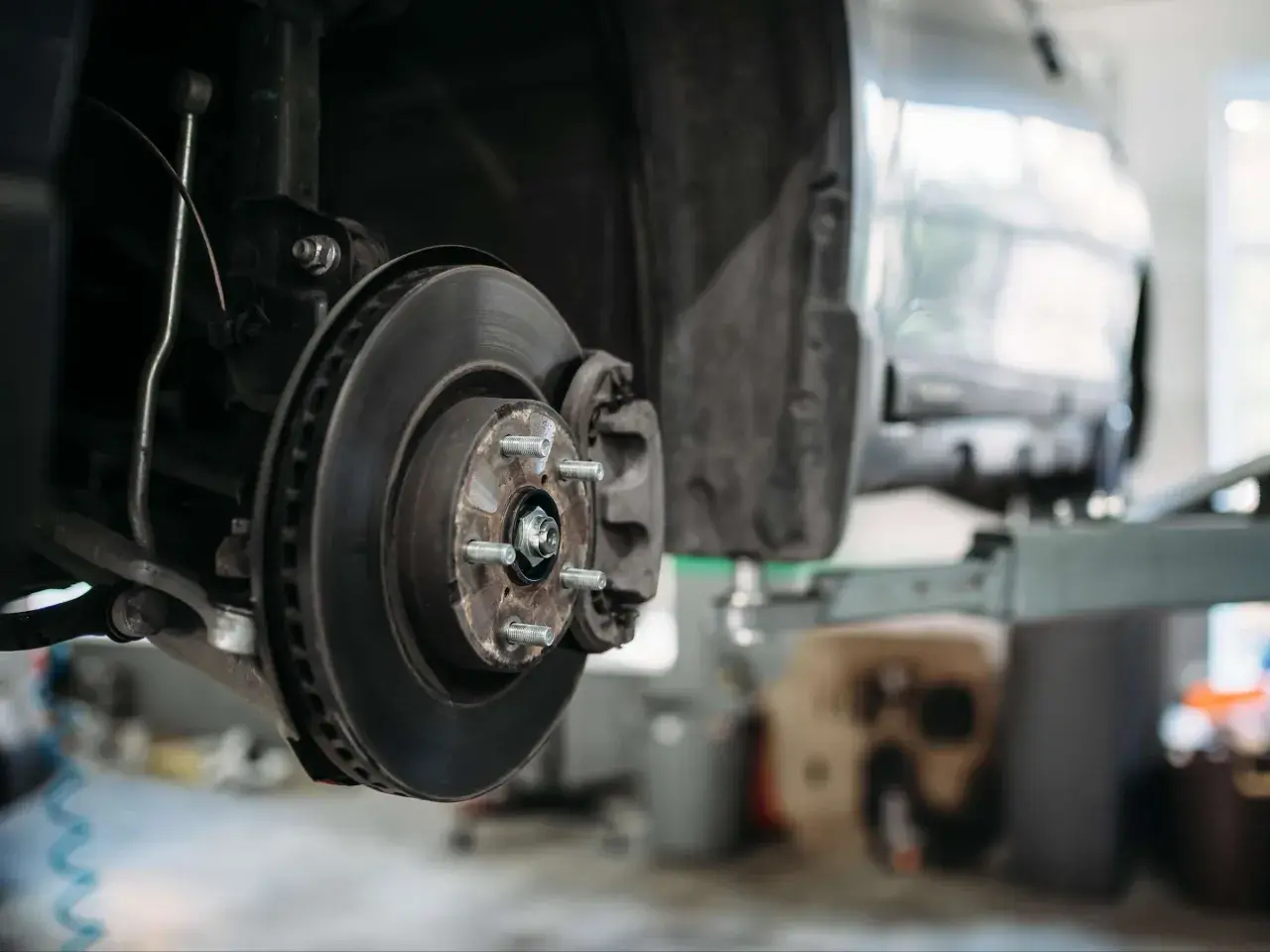 Nahaufnahme der Bremsscheibe und des Bremssattels eines PKW, bereit für Wartung oder Reparatur.