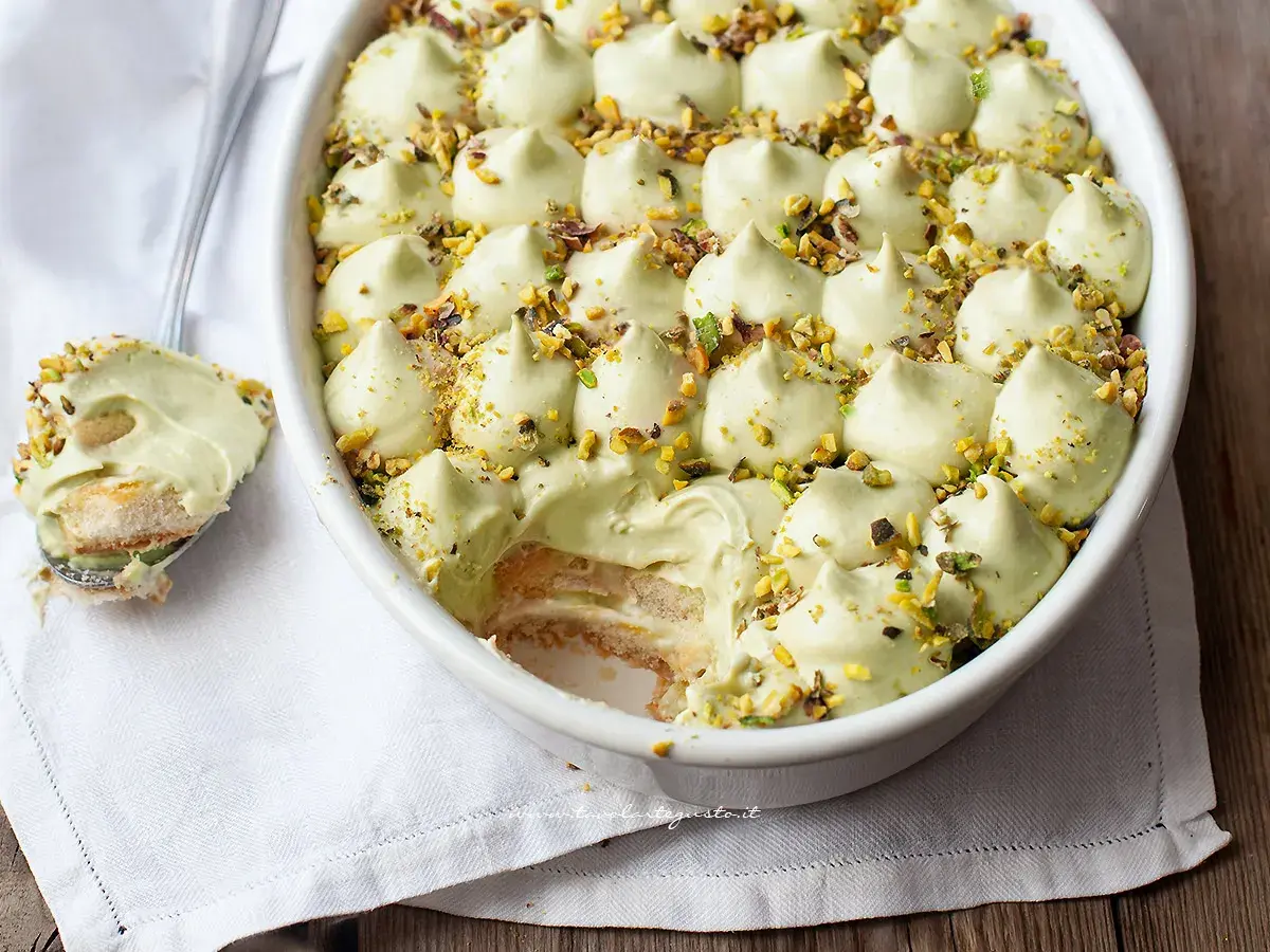 Un cremoso tiramisù al pistacchio, guarnito con granella di pistacchi, pronto per essere gustato.