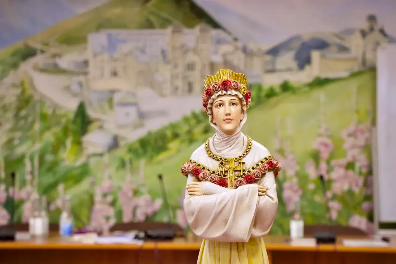 Figurka przedstawia postać z la salette objawienia, ubraną w białe szaty i złotą koronę z róż. Tło to malowidło górskiego krajobrazu.