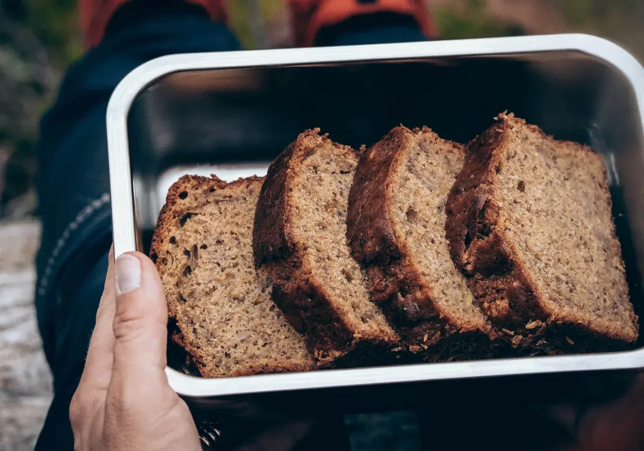 Skivor av saftig banankaka i en metallbehållare, perfekt för utflykten. Ett enkelt banankaka recept som passar alla.