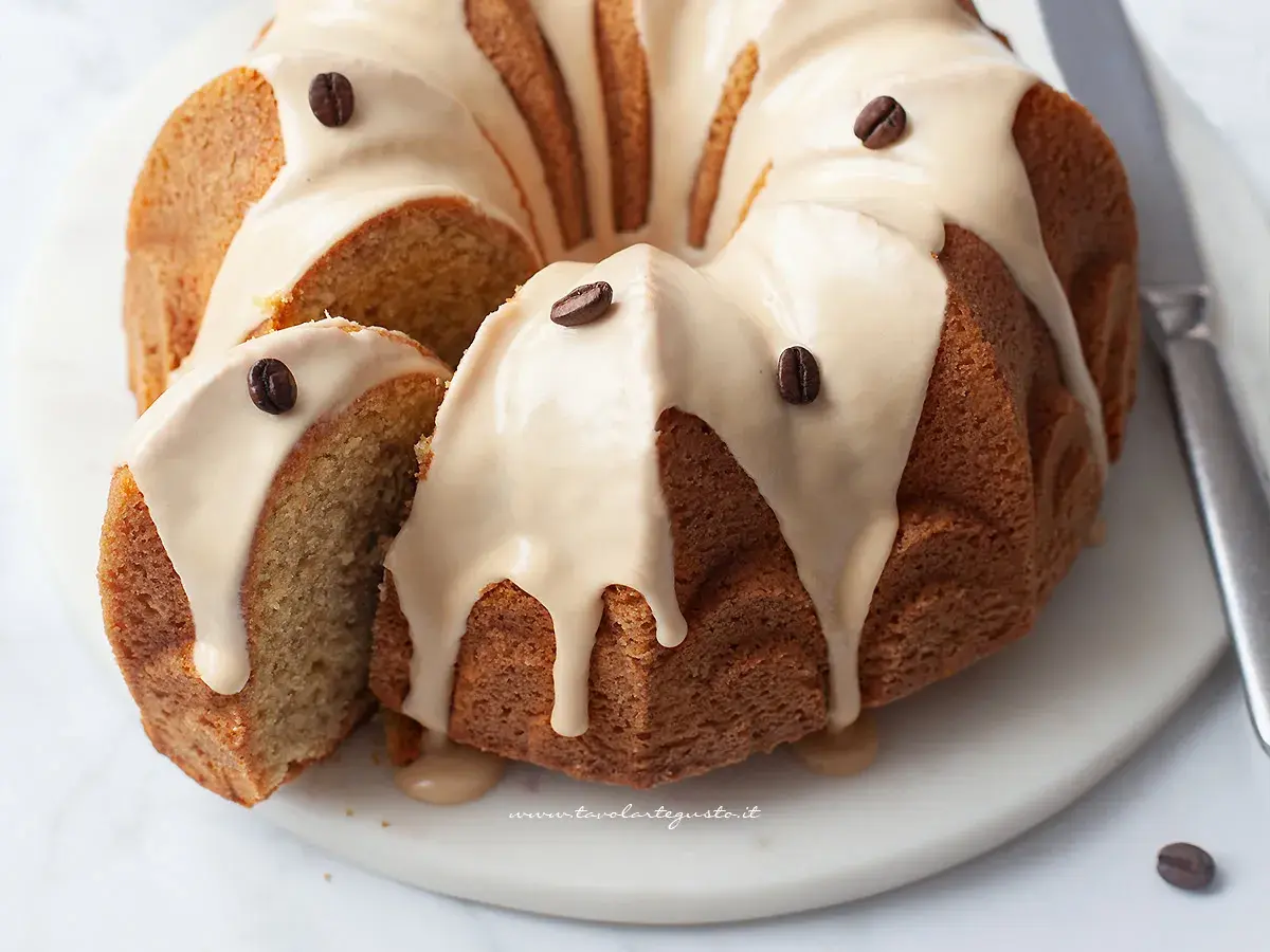 Deliziosa torta al caffè con glassa e chicchi di caffè, una fetta è stata tagliata per mostrare la morbidezza.