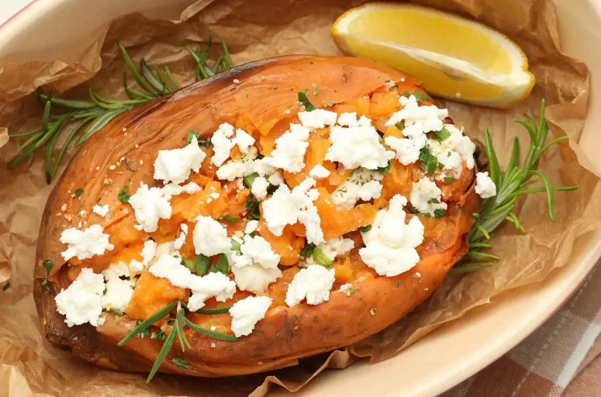 Pieczone bataty z fetą, posypane ziołami i podane z cytryną. Pyszne i zdrowe danie.