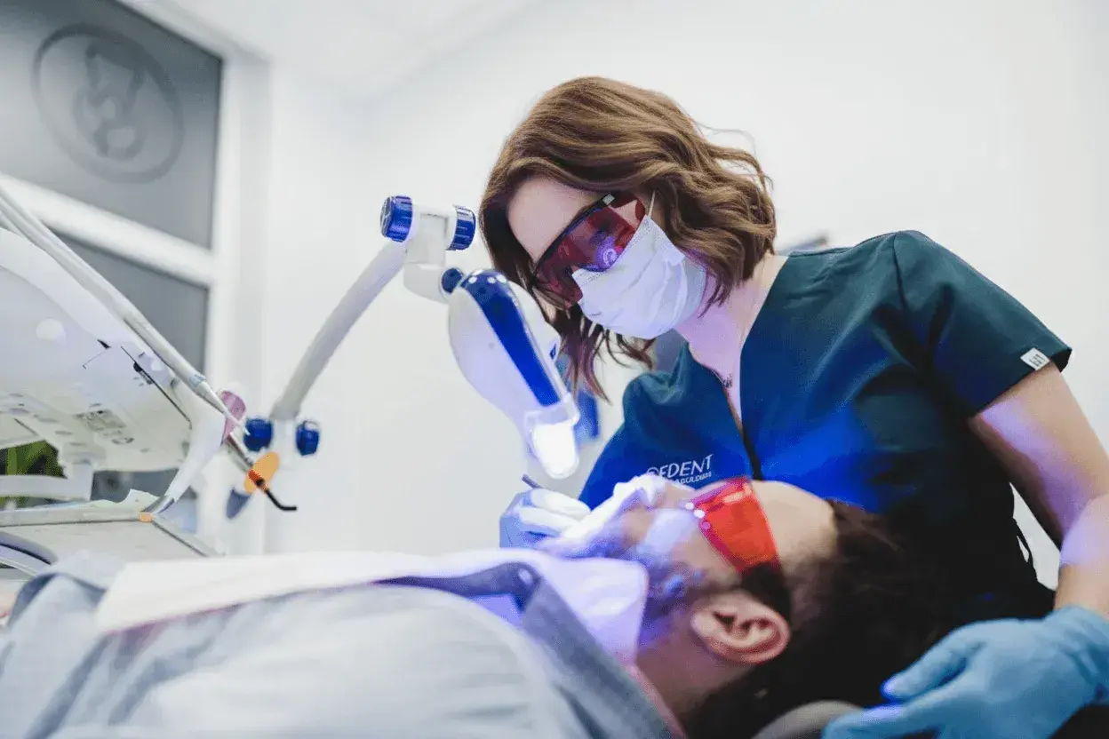 Dentystka wykonuje higienizację zębów w ciąży, dbając o zdrowy uśmiech przyszłej mamy.