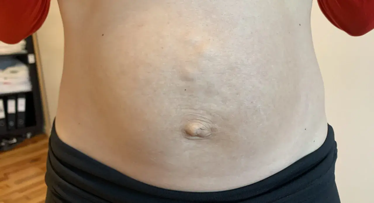 En mage med synliga delade magmuskler och navel.