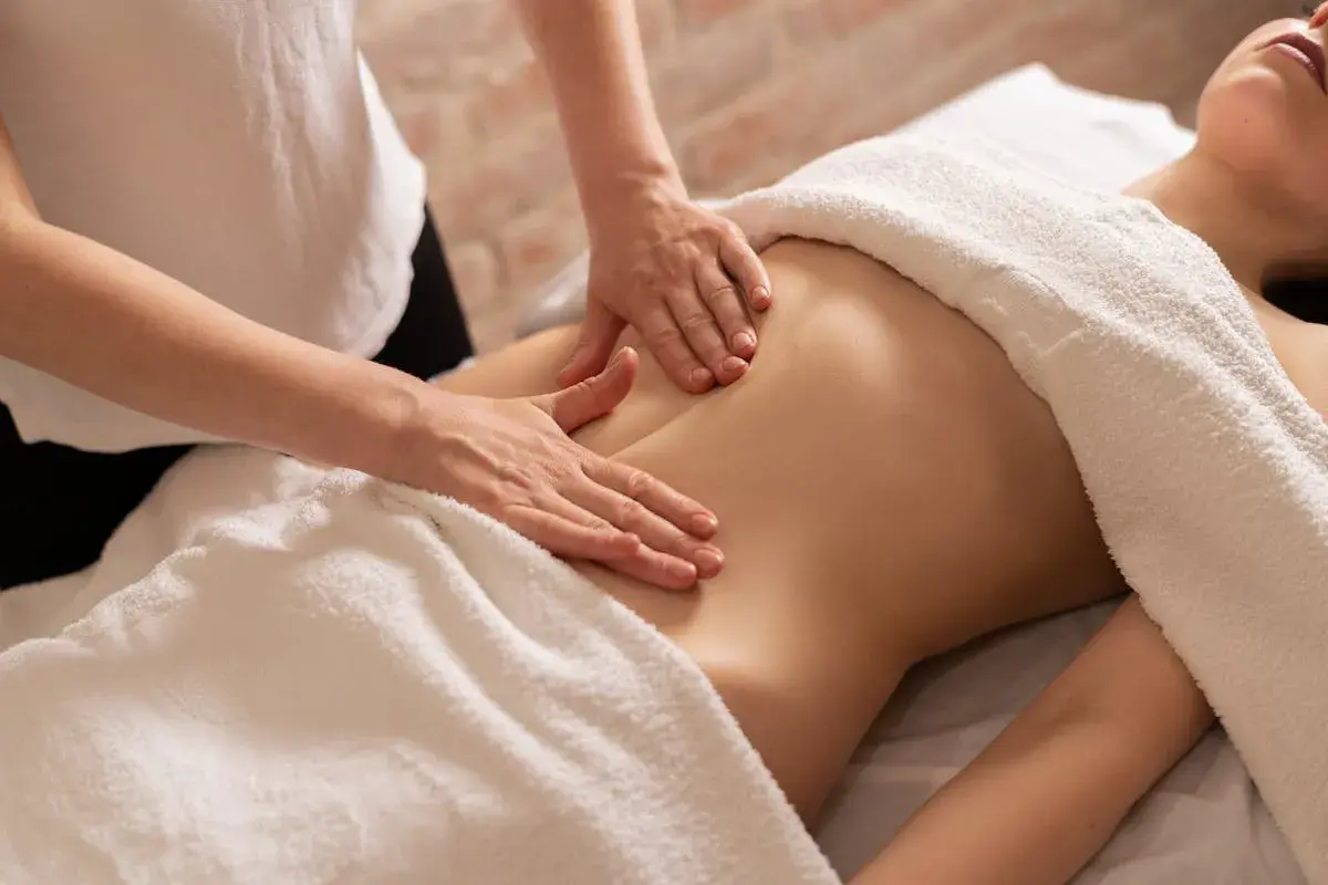 Mains douces prodiguant un massage ventre gonflé, apportant détente et soulagement.