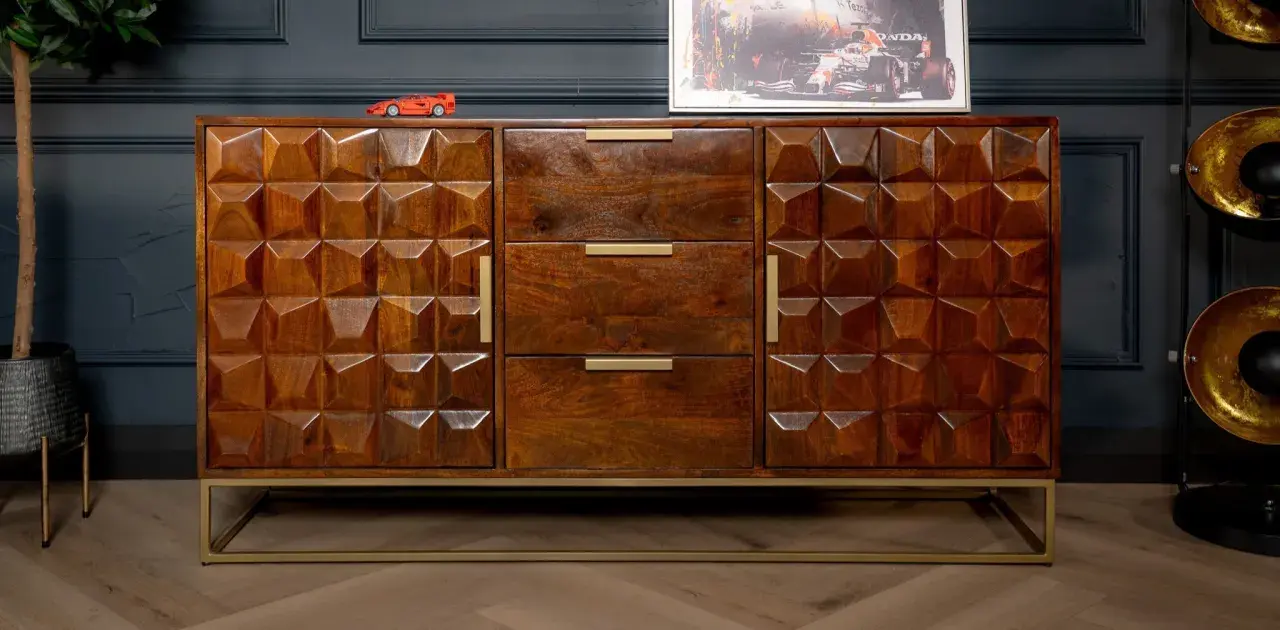 A geometric carved mango wood finish sideboard with brass handles and a gold metal base.