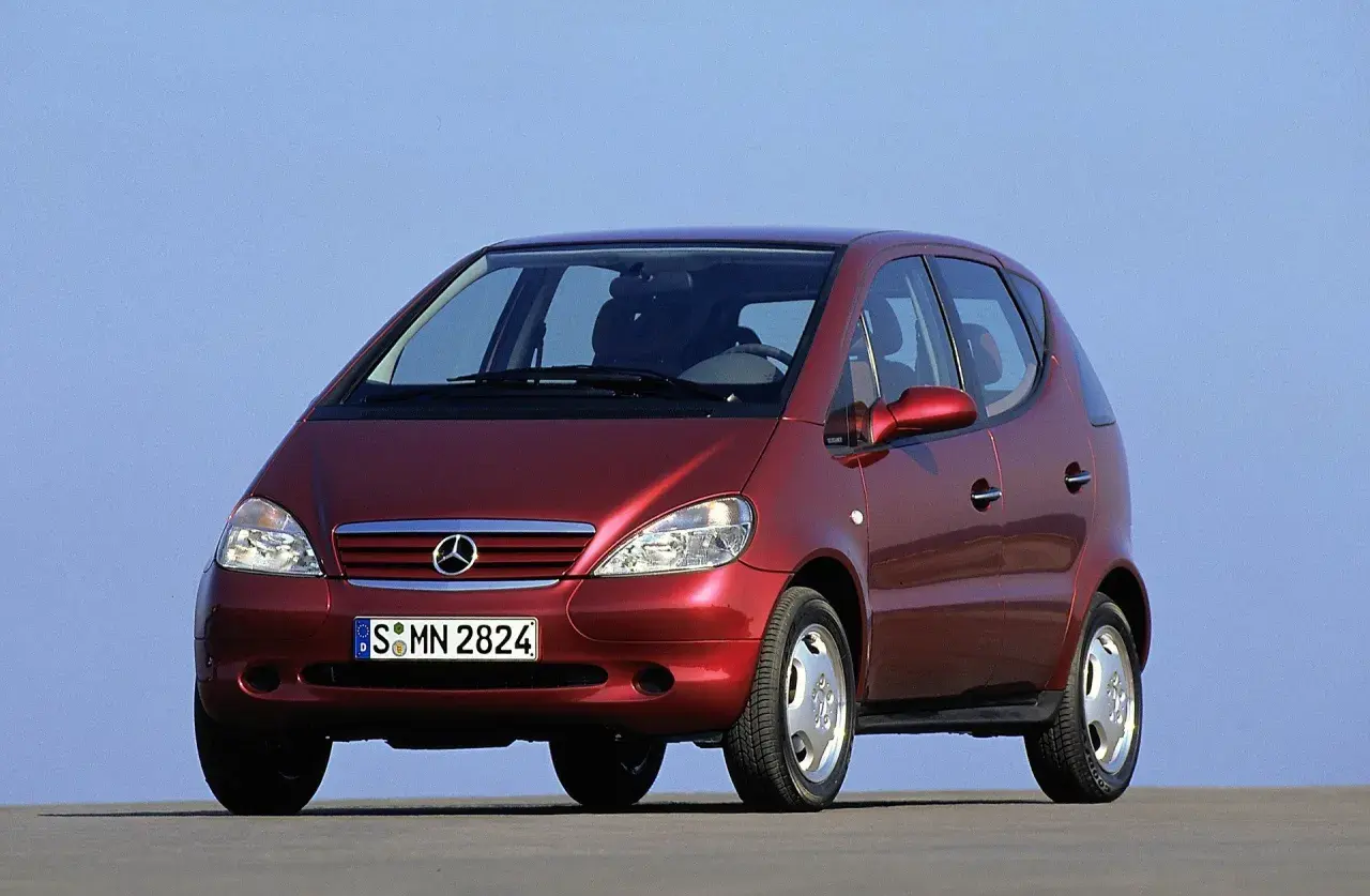 Czerwony Mercedes A Klasa 2001 z tablicą rejestracyjną S MN 2824, zaparkowany na tle błękitnego nieba.