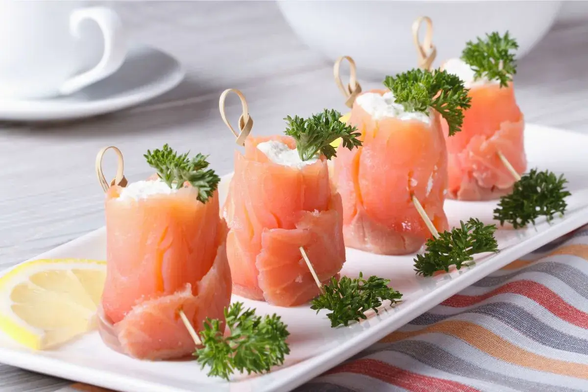Rotolini di salmone affumicato con formaggio cremoso e prezzemolo, perfetti per ricette fredde.