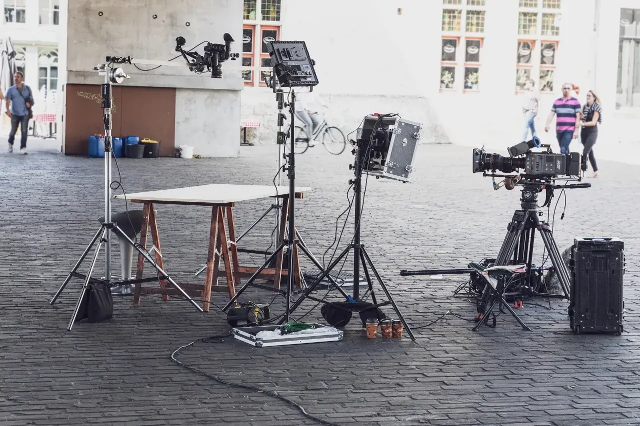 Profesjonalny sprzęt filmowy, w tym kamery i modyfikatory światła, gotowy do pracy na planie zdjęciowym.