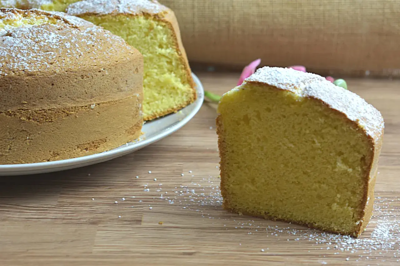 Un ciambellone soffice e alto, spolverato di zucchero a velo, pronto per essere gustato. La ricetta perfetta per una colazione golosa.