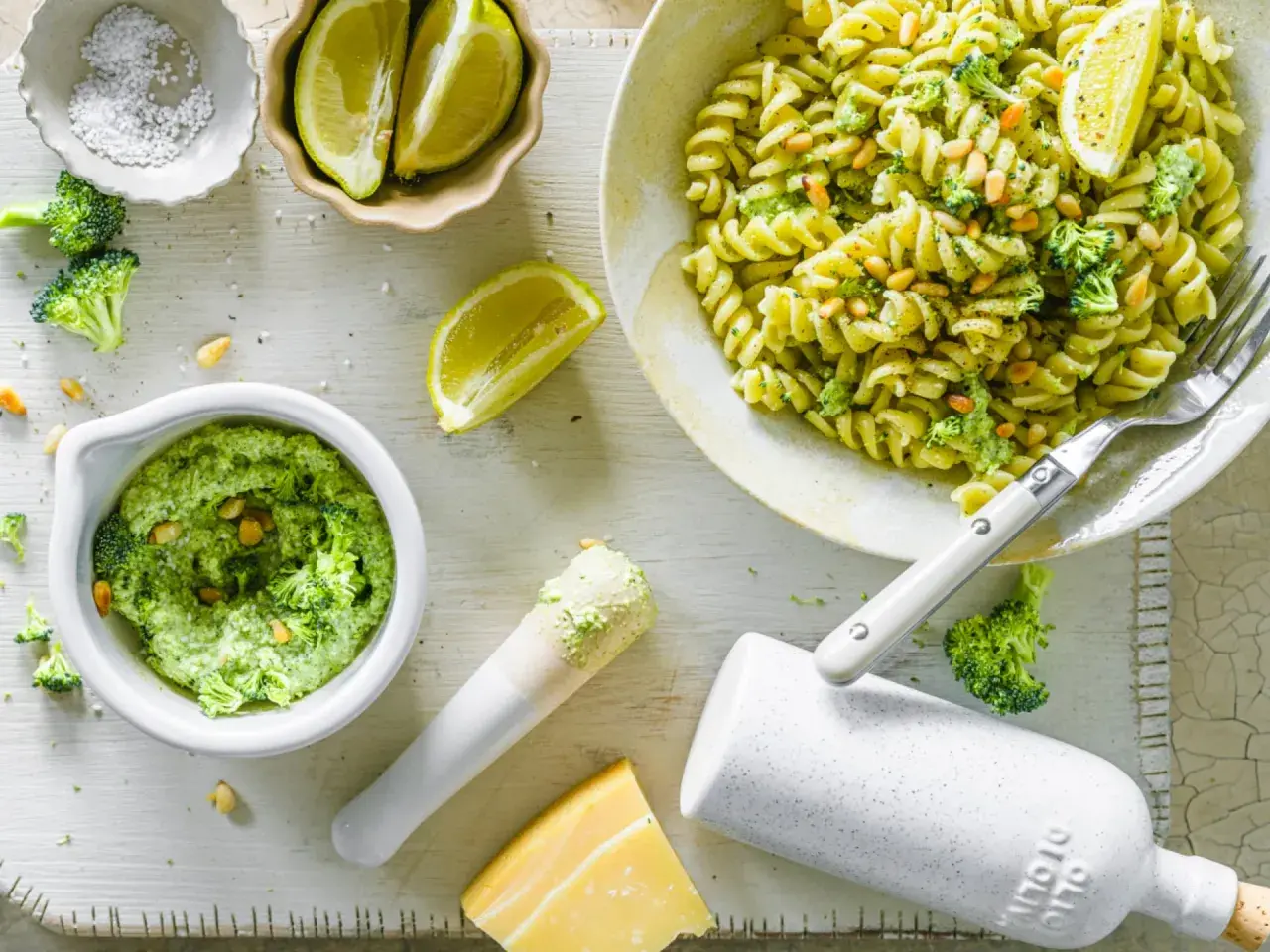 Frische Pasta mit cremigem Brokkoli Pesto, Pinienkernen und Zitrone. Zutaten für das Pesto sind sichtbar.